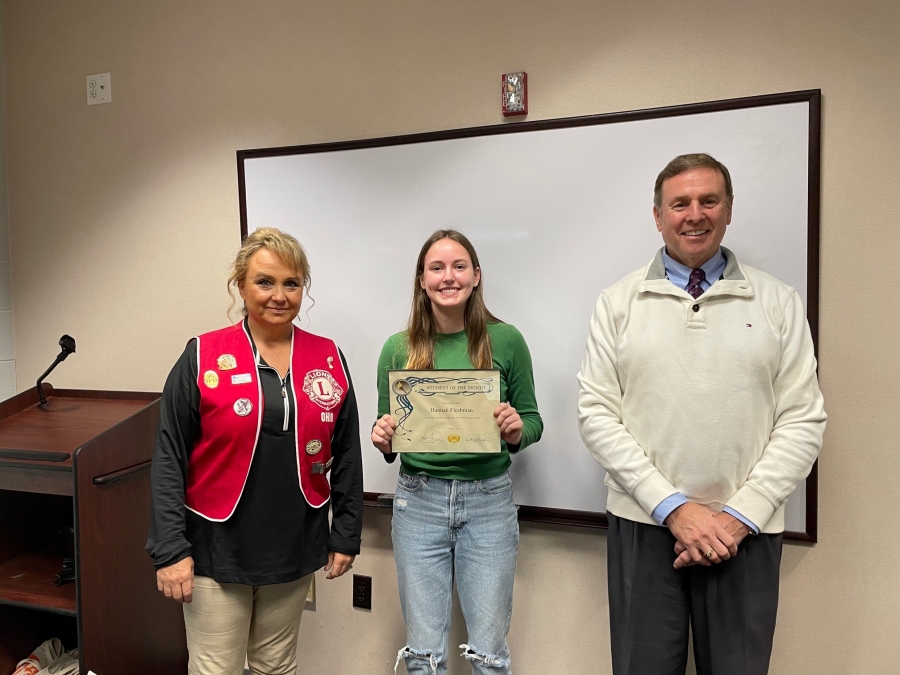 three people, one is holding a certificate